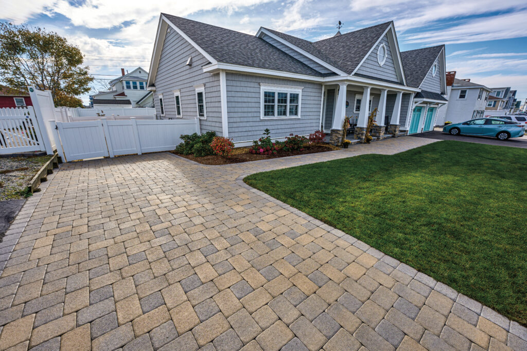 Two-story house with a gray shingle roof and a brick walkway